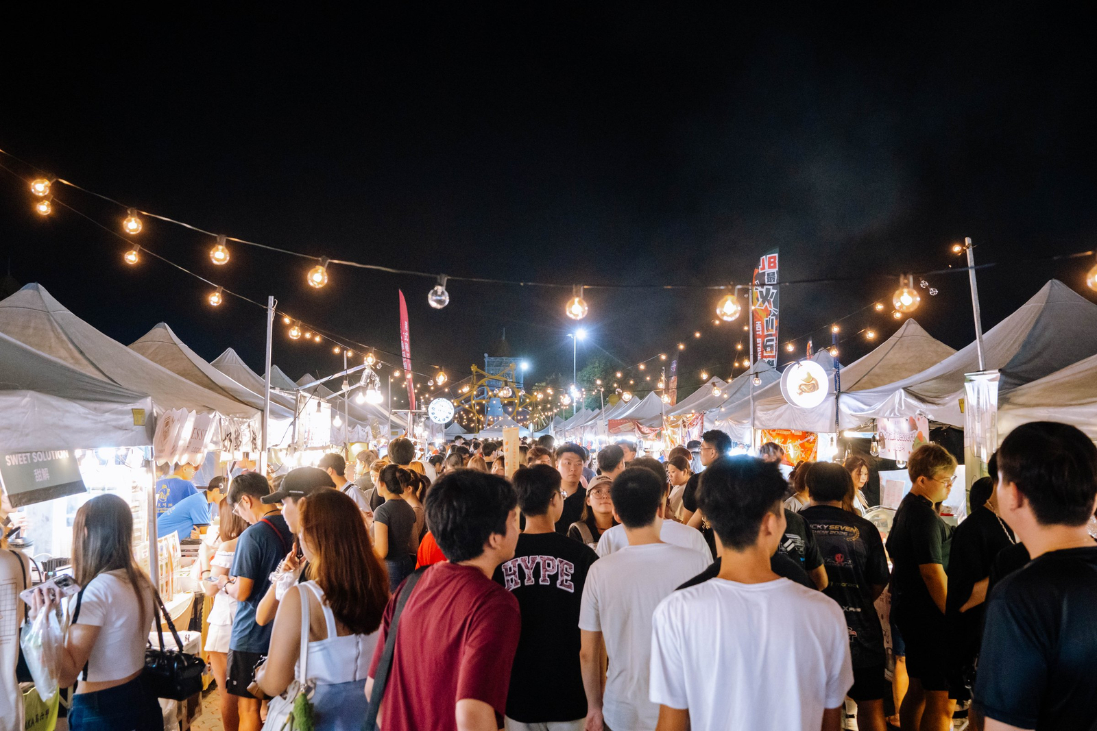 A busy night market lane lined with food vendors